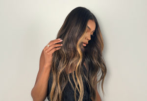 a black woman with a long, wavy highlighted wig