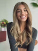 Honey brown wig with face-framing highlights and soft waves